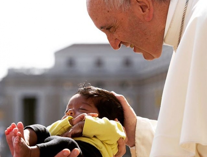 Pope Francis blesses a baby in St. Peter's Square. Pope Francis blesses a baby in St. Peter's Square.