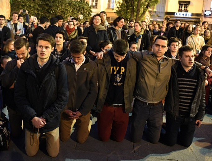 Onlookers, some holding rosaries, kneel and pray on the pavement as flames engulf Notre Dame Cathedral on April 15, 2019.
Onlookers, some holding rosaries, kneel and pray on the pavement as flames engulf Notre Dame Cathedral on April 15, 2019.