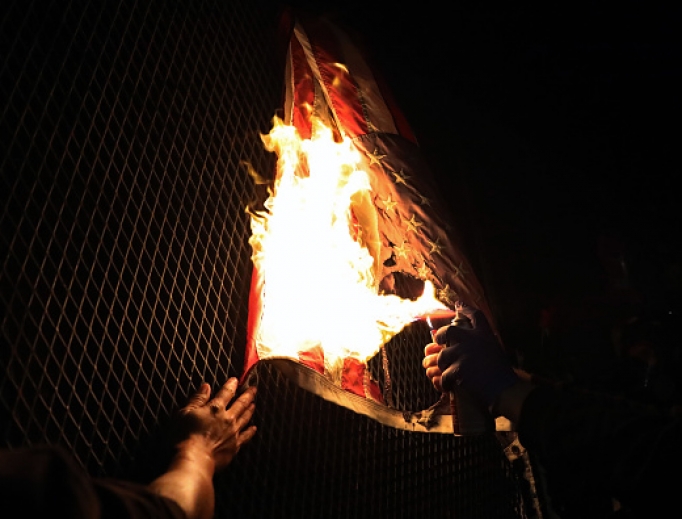 An American Flag is burned as protesters gather in front of the Mark O. Hatfield federal courthouse in downtown Portland as the city experiences another night of unrest on July 25, 2020 in Portland, Oregon. For over 55 straight nights, protesters in downtown Portland have faced off in often violent clashes with the Portland Police Bureau. An American Flag is burned as protesters gather in front of the Mark O. Hatfield federal courthouse in downtown Portland as the city experiences another night of unrest on July 25, 2020 in Portland, Oregon. For over 55 straight nights, protesters in downtown Portland have faced off in often violent clashes with the Portland Police Bureau.
