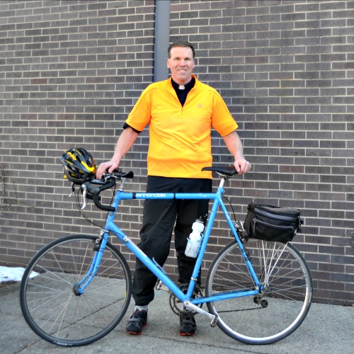 Father James Sullivan, shown with his 25-year-old bike, wears his clerics on rides. Father James Sullivan, shown with his 25-year-old bike, wears his clerics on rides.