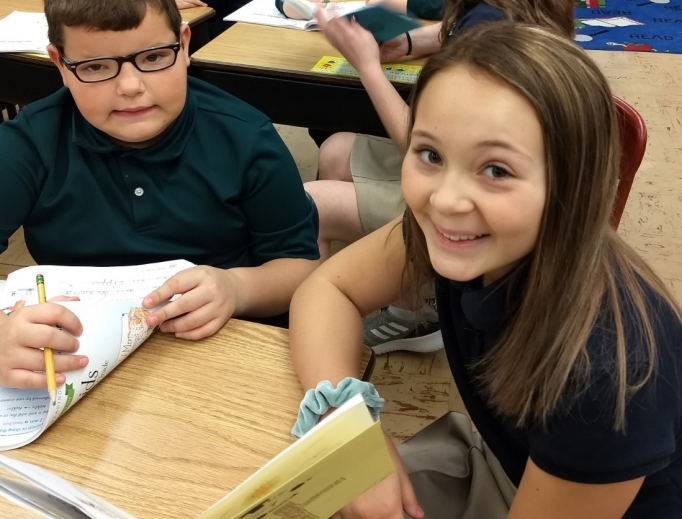 In Escanaba, Michigan, Holy Name Catholic School middle-school students often work with younger students on reading and comprehension. Above, 2020 eighth-grader Sophia Derkos and elementary student Nicholas Flath smile as they work together on a reading project. Below, Second photo: 2020 eighth-grader Natalie Williams reads with elementary students Kinley Hastings and Thomas Carlson. In the background, 2020 eighth-grader Annabelle Neumeier reads to elementary students.
In Escanaba, Michigan, Holy Name Catholic School middle-school students often work with younger students on reading and comprehension. Above, 2020 eighth-grader Sophia Derkos and elementary student Nicholas Flath smile as they work together on a reading project. Below, Second photo: 2020 eighth-grader Natalie Williams reads with elementary students Kinley Hastings and Thomas Carlson. In the background, 2020 eighth-grader Annabelle Neumeier reads to elementary students.