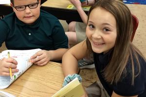 In Escanaba, Michigan, Holy Name Catholic School middle-school students often work with younger students on reading and comprehension. Above, 2020 eighth-grader Sophia Derkos and elementary student Nicholas Flath smile as they work together on a reading project. Below, Second photo: 2020 eighth-grader Natalie Williams reads with elementary students Kinley Hastings and Thomas Carlson. In the background, 2020 eighth-grader Annabelle Neumeier reads to elementary students.
In Escanaba, Michigan, Holy Name Catholic School middle-school students often work with younger students on reading and comprehension. Above, 2020 eighth-grader Sophia Derkos and elementary student Nicholas Flath smile as they work together on a reading project. Below, Second photo: 2020 eighth-grader Natalie Williams reads with elementary students Kinley Hastings and Thomas Carlson. In the background, 2020 eighth-grader Annabelle Neumeier reads to elementary students.