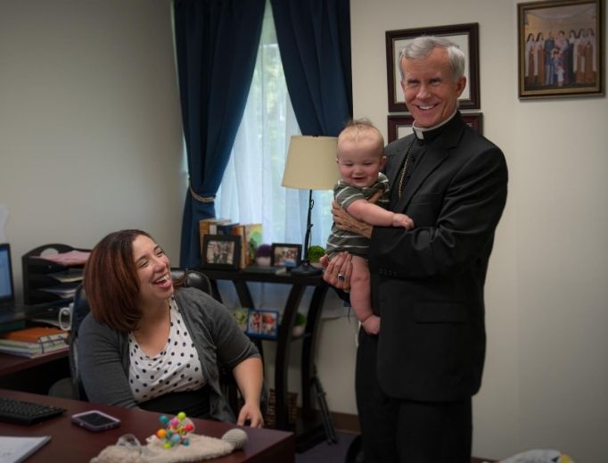Deanna Johnston, director for family life, at the St. Philip Institute looks on as Bishop Joseph Strickland holds her baby. Deanna Johnston, director for family life, at the St. Philip Institute looks on as Bishop Joseph Strickland holds her baby.