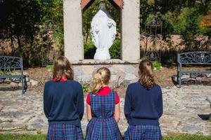 Above, students pray at the Trinity Academy outdoor Shrine to Our Lady of the Miraculous Medal, the site of the school Eucharistic procession. Below, Michael Moynihan instructs students in the classroom at The Heights.