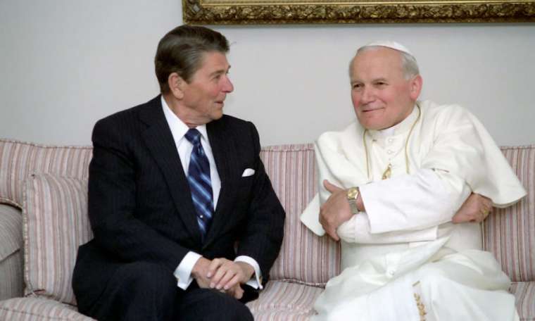U.S. President Ronald Reagan talks with Pope St. John Paul II. U.S. President Ronald Reagan talks with Pope St. John Paul II.