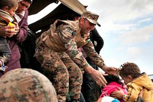 Jordanian troops and UNHCR officials help bring Syrian refugees to Jordan’s Zaatari refugee camp. Jordanian troops and UNHCR officials help bring Syrian refugees to Jordan’s Zaatari refugee camp.