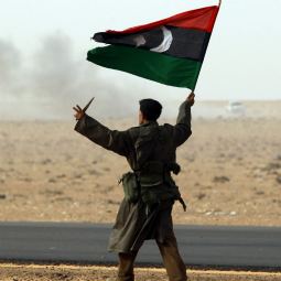 A rebel fighter holds a Kingdom of Libya flag and a knife during battle with soldiers loyal to Libyan leader Col. Moammar Gadhafi near Ras Lanuf, a major oil port in Libya, March 4. A rebel fighter holds a Kingdom of Libya flag and a knife during battle with soldiers loyal to Libyan leader Col. Moammar Gadhafi near Ras Lanuf, a major oil port in Libya, March 4.