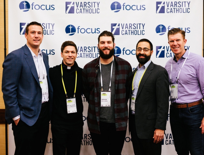 Above, l to r:Joe Reitz (former NFL player), Father Chase Hilgenbrinck (former MLS player), Trevor Williams (starting pitcher for the Pittsburgh Pirates), Thomas Wurtz of Varsity Catholic and Matt Birk (former NFL player) attend a Varsity Catholic event at the 'Seek' conference hosted by Fellowship of Catholic University Students. Below, Wurtz (l) and Lou Holtz (c) chat with Calvin Mueller (r) at 'Seek.' Above, l to r:Joe Reitz (former NFL player), Father Chase Hilgenbrinck (former MLS player), Trevor Williams (starting pitcher for the Pittsburgh Pirates), Thomas Wurtz of Varsity Catholic and Matt Birk (former NFL player) attend a Varsity Catholic event at the 'Seek' conference hosted by Fellowship of Catholic University Students. Below, Wurtz (l) and Lou Holtz (c) chat with Calvin Mueller (r) at 'Seek.'