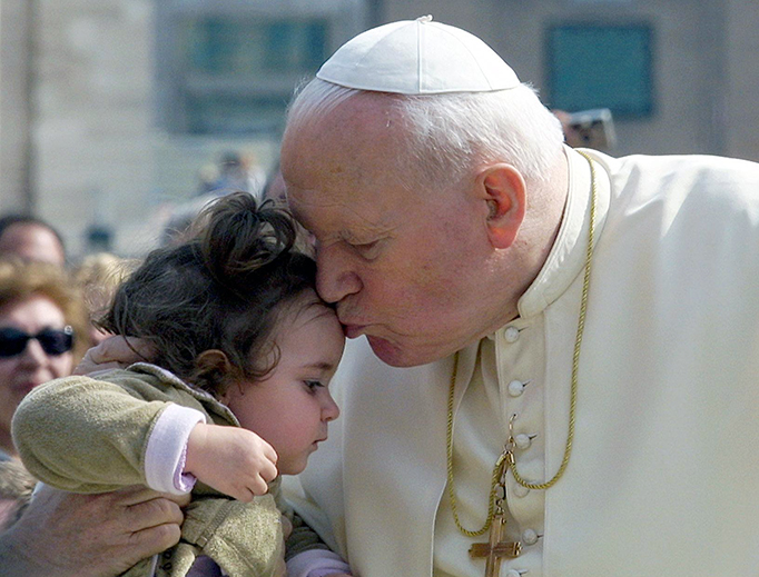 Pope John Paul II kisses a child as he arrives at St. Peter's Square at the Vatican, March 20, 2002, to preside his first open air weekly general audience of the year. Pope John Paul II kisses a child as he arrives at St. Peter's Square at the Vatican, March 20, 2002, to preside his first open air weekly general audience of the year.