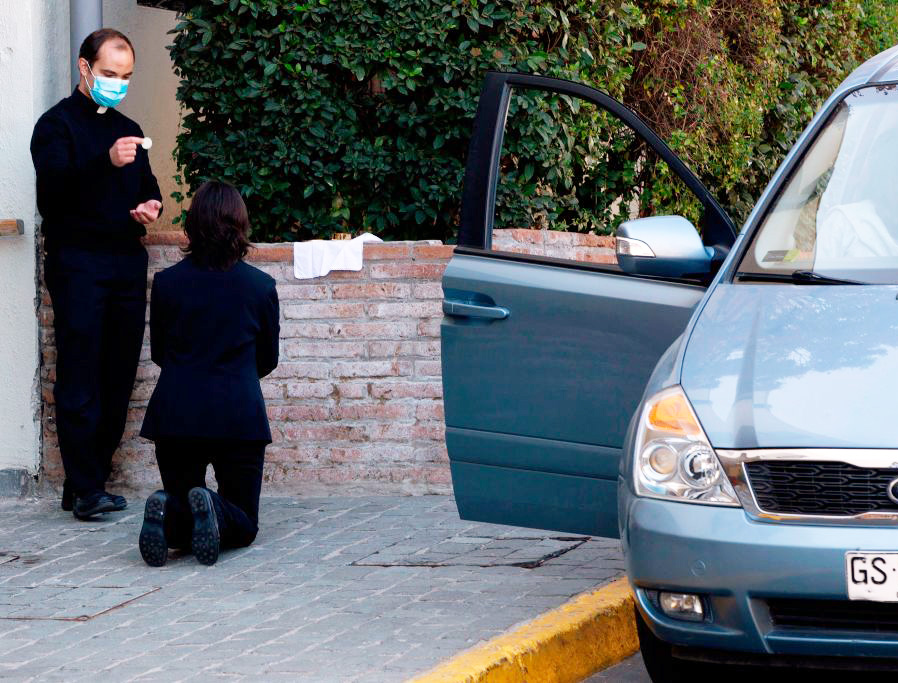 A priest distributes Holy Communion May 5 in front of San Francisco de Asís parish in Santiago, Chile. A priest distributes Holy Communion May 5 in front of San Francisco de Asís parish in Santiago, Chile.