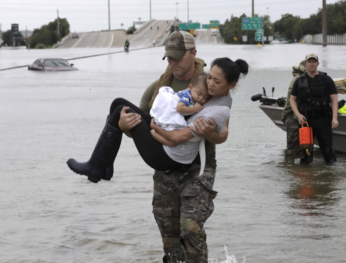 Houston Police SWAT officer Daryl Hudeck carries Catherine Pham and her 13-month-old son, Aiden, after rescuing them from their home surrounded by floodwaters from Tropical Storm Harvey Aug. 27 in Houston. The remnants of Hurricane Harvey sent devastating floods pouring into Houston Sunday as rising water chased thousands of people to rooftops or higher ground. Houston Police SWAT officer Daryl Hudeck carries Catherine Pham and her 13-month-old son, Aiden, after rescuing them from their home surrounded by floodwaters from Tropical Storm Harvey Aug. 27 in Houston. The remnants of Hurricane Harvey sent devastating floods pouring into Houston Sunday as rising water chased thousands of people to rooftops or higher ground.