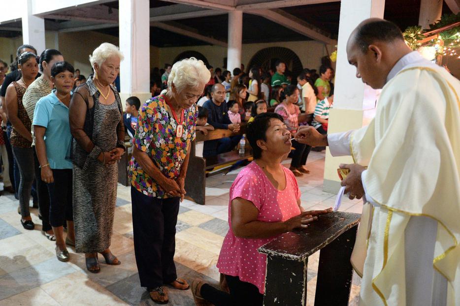 Survivors of Super Typhoon Haiyan receive Holy Communion in the Philippine village of San Joaquin in Palo on Dec. 24, 2013.
Survivors of Super Typhoon Haiyan receive Holy Communion in the Philippine village of San Joaquin in Palo on Dec. 24, 2013.