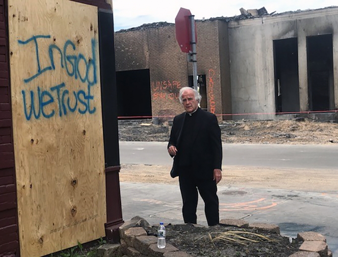 Above, Dominican Father Joseph Gillespie, the pastor of St. Albert the Great in south Minneapolis, stands by a hopeful message amid destruction in his parish neighborhood. The area was looted during violent protests following the death of George Floyd at the end of May. Above, Dominican Father Joseph Gillespie, the pastor of St. Albert the Great in south Minneapolis, stands by a hopeful message amid destruction in his parish neighborhood. The area was looted during violent protests following the death of George Floyd at the end of May.