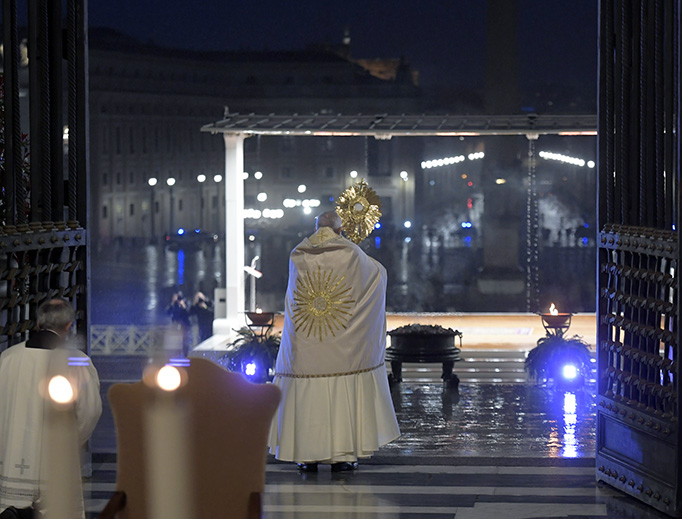 Holding the Blessed Sacrament in a monstrance, Pope Francis stands before an empty St. Peter’s Square — and a large TV, radio and internet audience worldwide — as he blesses “the City (of Rome) and the World” (Urbi et Orbi) Friday. Holding the Blessed Sacrament in a monstrance, Pope Francis stands before an empty St. Peter’s Square — and a large TV, radio and internet audience worldwide — as he blesses “the City (of Rome) and the World” (Urbi et Orbi) Friday.