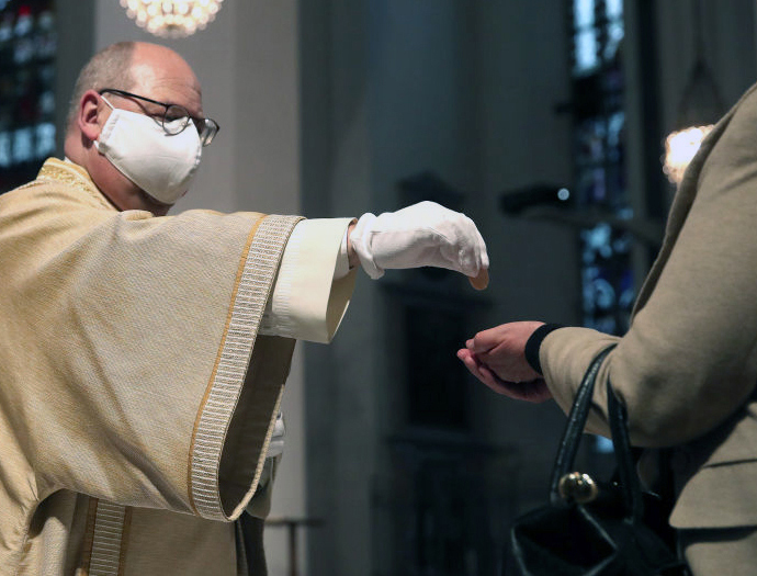 A deacon distributes Holy Communion during Mass Monday at the Frauenkirche (Cathedral of Our Lady) in Munich, Germany, the first day since March that churches were open in Bavaria. Nationwide state and local governments are easing lockdown measures that were imposed in order to stem the spread of the new coronavirus. A deacon distributes Holy Communion during Mass Monday at the Frauenkirche (Cathedral of Our Lady) in Munich, Germany, the first day since March that churches were open in Bavaria. Nationwide state and local governments are easing lockdown measures that were imposed in order to stem the spread of the new coronavirus.