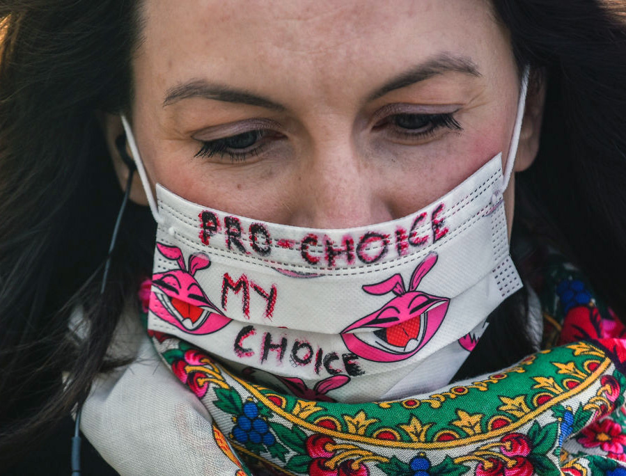 A pro-abortion activist wears a protective mask and holds a banner as she takes part in a protest in front of a supermarket at Krakow’s Unesco Main Square during the government-announced lockdown to tackle the coronavirus spread on April 15, 2020, in Krakow, Poland. A pro-abortion activist wears a protective mask and holds a banner as she takes part in a protest in front of a supermarket at Krakow’s Unesco Main Square during the government-announced lockdown to tackle the coronavirus spread on April 15, 2020, in Krakow, Poland.