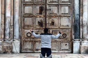 A man kneels in prayer in front of the closed doors of the Church of the Holy Sepulcher in Jerusalem April 9, during the COVID-19 pandemic lockdown. A man kneels in prayer in front of the closed doors of the Church of the Holy Sepulcher in Jerusalem April 9, during the COVID-19 pandemic lockdown.