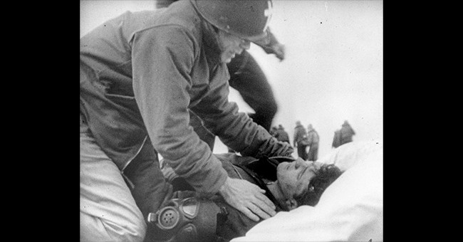 Lieutenant Commander Joseph T. O'Callahan, USNR(ChC) prepares to anoint an injured crewman aboard USS Franklin (CV-13), after the ship was set afire by a Japanese air attack, 19 March 1945. The crewman is reportedly Robert C. Blanchard, who survived his injuries. (Credit: Naval Historical Center) Lieutenant Commander Joseph T. O'Callahan, USNR(ChC) prepares to anoint an injured crewman aboard USS Franklin (CV-13), after the ship was set afire by a Japanese air attack, 19 March 1945. The crewman is reportedly Robert C. Blanchard, who survived his injuries. (Credit: Naval Historical Center)