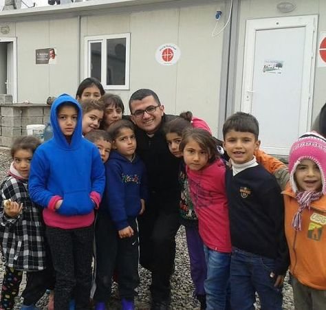 Seminarian Remi Marzina Momica with a group of children outside an Aid to the Church in Need office. Seminarian Remi Marzina Momica with a group of children outside an Aid to the Church in Need office.