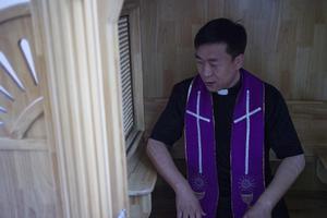 Chinese priest Lin Xiuqiang poses for a photograph in his Catholic church in Tianjin. Dozens of church buildings have been demolished and crosses removed in recent months. Chinese priest Lin Xiuqiang poses for a photograph in his Catholic church in Tianjin. Dozens of church buildings have been demolished and crosses removed in recent months.