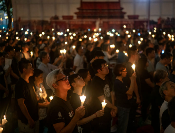 Above, people hold candles as they take part in a candlelight vigil at Victoria Park June 4 in Hong Kong. Cities held events around the world on June 4 to remember those who died when Chinese troops cracked down on pro-democracy protesters 30 years ago and killed from hundreds to thousands in Beijing. Below, Chinese onlookers run away as a soldier threatens them with a gun on June 5, 1989, as tanks took position at Beijing's key intersections next to the diplomatic compound. Above, people hold candles as they take part in a candlelight vigil at Victoria Park June 4 in Hong Kong. Cities held events around the world on June 4 to remember those who died when Chinese troops cracked down on pro-democracy protesters 30 years ago and killed from hundreds to thousands in Beijing. Below, Chinese onlookers run away as a soldier threatens them with a gun on June 5, 1989, as tanks took position at Beijing's key intersections next to the diplomatic compound.