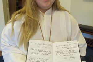 Kara Jackson, a young woman with Down syndrome who wants to serve Mass in all 50 states, in Northglenn, Colo. Kara’s notebook filled with messages from priests documents her journey. Kara Jackson, a young woman with Down syndrome who wants to serve Mass in all 50 states, in Northglenn, Colo. Kara’s notebook filled with messages from priests documents her journey.
