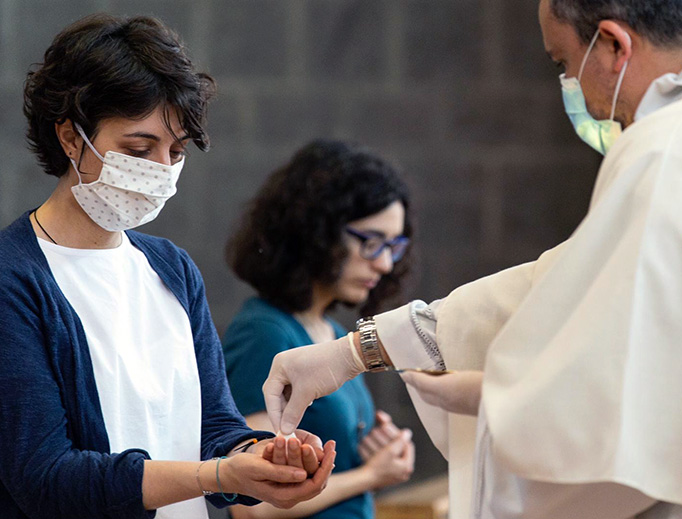 A priest distributes Holy Communion in Italy on Monday. A priest distributes Holy Communion in Italy on Monday.