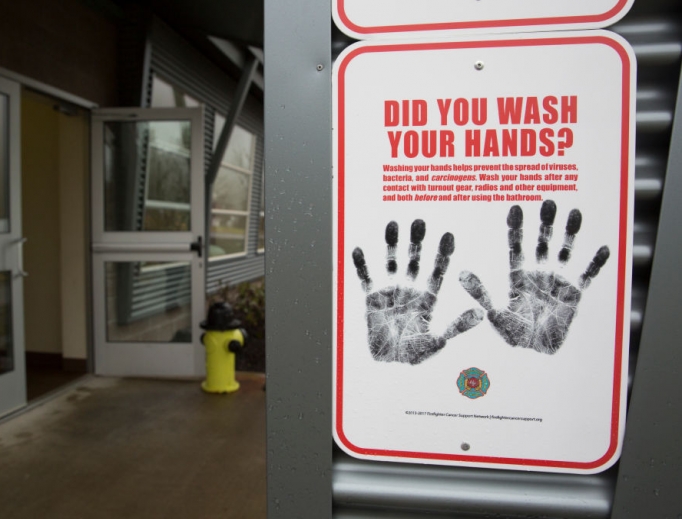 Above, a sign reminding people to wash their hands is pictured outside a dormitory at the Washington State Patrol Fire Training Academy, which has been designated as a coronavirus quarantine site for travelers from Hubei Province, China. Below, Dr./Deacon Timothy Flanigan sanitizes his hands at a Liberia medical clinic. Dr. Flanigan is an infectious disease specialist at the medical school at Brown University and assisted with the recent Ebola outbreak.
Above, a sign reminding people to wash their hands is pictured outside a dormitory at the Washington State Patrol Fire Training Academy, which has been designated as a coronavirus quarantine site for travelers from Hubei Province, China. Below, Dr./Deacon Timothy Flanigan sanitizes his hands at a Liberia medical clinic. Dr. Flanigan is an infectious disease specialist at the medical school at Brown University and assisted with the recent Ebola outbreak.