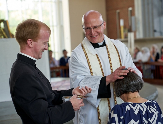 Father Michael Cunningham gives a priestly blessing. Father Michael Cunningham gives a priestly blessing.