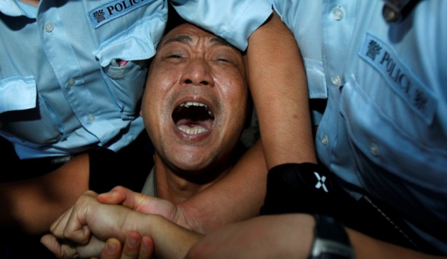 Hong Kong police arrest a pro-democracy protester Oct. 1 during a demonstration demanding China improve its human rights record, outside the Chinese liaison office in Hong Kong. Hong Kong police arrest a pro-democracy protester Oct. 1 during a demonstration demanding China improve its human rights record, outside the Chinese liaison office in Hong Kong.