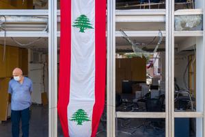 A man stands in the window of a damaged high-rise building, draped with banner in the style of the Lebanese flag, on August 12, 2020 in Beirut, Lebanon. The explosion at Beirut's port last week killed over 200 people, injured thousands, and upended countless lives. There has been little visible support from government agencies to help residents clear debris and help the displaced, although scores of volunteers from around Lebanon have descended on the city to help clean. A man stands in the window of a damaged high-rise building, draped with banner in the style of the Lebanese flag, on August 12, 2020 in Beirut, Lebanon. The explosion at Beirut's port last week killed over 200 people, injured thousands, and upended countless lives. There has been little visible support from government agencies to help residents clear debris and help the displaced, although scores of volunteers from around Lebanon have descended on the city to help clean.