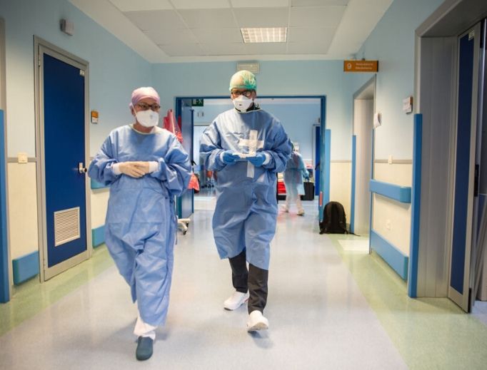 A priest (c) walks through the Intensive Care Unit and prepares to give a blessing and Holy Communion to patients for Easter on April 12 in Sant’Orsola Hospital in Bologna, Italy. Worldwide, including in the U.S., priests are suiting up in protective gear to anoint the sick amid the pandemic. A priest (c) walks through the Intensive Care Unit and prepares to give a blessing and Holy Communion to patients for Easter on April 12 in Sant’Orsola Hospital in Bologna, Italy. Worldwide, including in the U.S., priests are suiting up in protective gear to anoint the sick amid the pandemic.