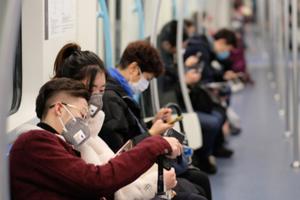 People wearing surgical masks sitting on a subway in Shanghai, January 2020. People wearing surgical masks sitting on a subway in Shanghai, January 2020.