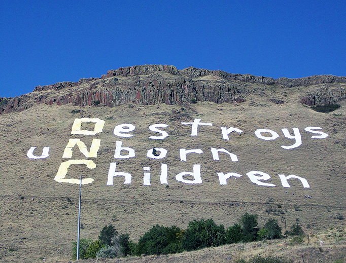 Abortion protest sign on North Table Mountain outside Denver, during the 2008 Democratic National Convention. The sign reads "(DNC) Destroys uNborn Children" and is made of sheets sown together. Abortion protest sign on North Table Mountain outside Denver, during the 2008 Democratic National Convention. The sign reads "(DNC) Destroys uNborn Children" and is made of sheets sown together.