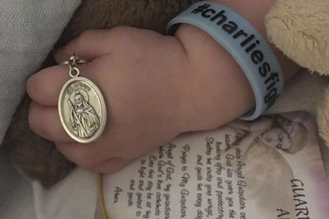 Charlie Gard holds metal of St. Jude Charlie Gard holds metal of St. Jude