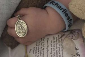 Charlie Gard holds metal of St. Jude Charlie Gard holds metal of St. Jude