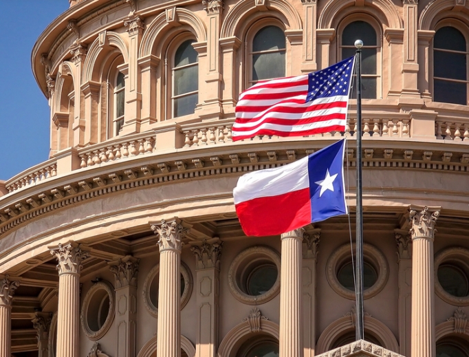 American and Texas state flags flying on the dome of the Texas State Capitol building in Austin. American and Texas state flags flying on the dome of the Texas State Capitol building in Austin.