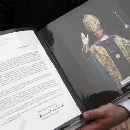 Msgr. Stanley Deptula, executive director of the Archbishop Fulton John Sheen Foundation, holds a volume containing letters from cardinals and bishops supporting the sainthood cause of Archbishop Fulton J. Sheen in Rome May 24. Msgr. Stanley Deptula, executive director of the Archbishop Fulton John Sheen Foundation, holds a volume containing letters from cardinals and bishops supporting the sainthood cause of Archbishop Fulton J. Sheen in Rome May 24.