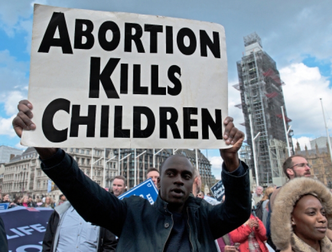 Man holds a sign at the March for Life in London, England, May 11, 2019. Man holds a sign at the March for Life in London, England, May 11, 2019.