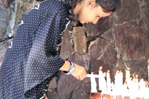 A young girl lights a candle at a Marian grotto in Pakistan. A young girl lights a candle at a Marian grotto in Pakistan.