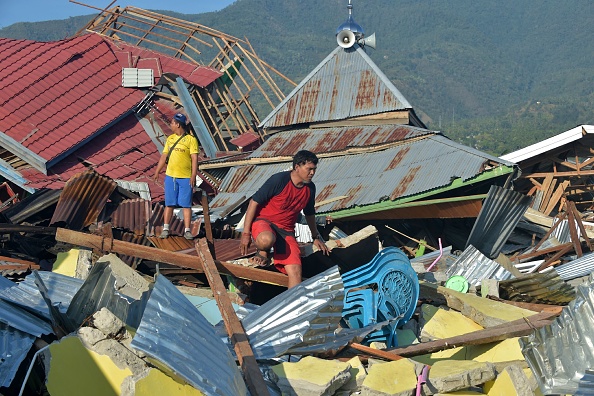 People inspect damaged houses in Palu Oct. 1, after an earthquake and tsunami hit the area Sept. 28. People inspect damaged houses in Palu Oct. 1, after an earthquake and tsunami hit the area Sept. 28.