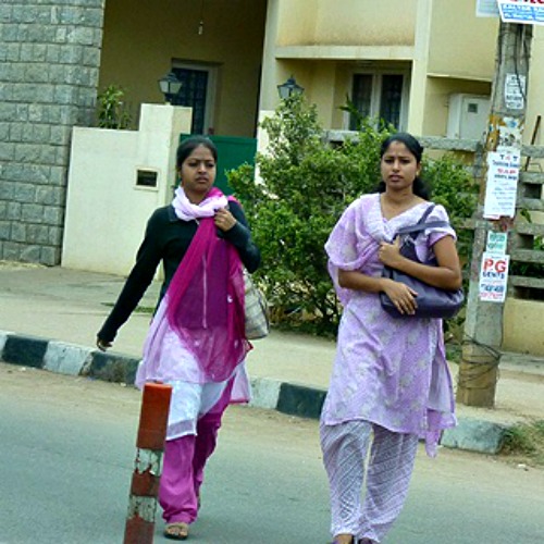 Young women walk along a street in Bangalore, India. Young women walk along a street in Bangalore, India.