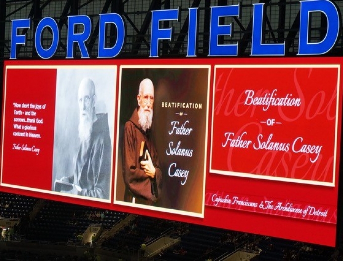 Above, the JumboTron announces the holy event at Ford Field Nov. 18; below, the thousands in attendance, Cardinal Angelo Amato celebrating the Mass, and the official portrait of Blessed Solanus Casey seen center stage. Above, the JumboTron announces the holy event at Ford Field Nov. 18; below, the thousands in attendance, Cardinal Angelo Amato celebrating the Mass, and the official portrait of Blessed Solanus Casey seen center stage.