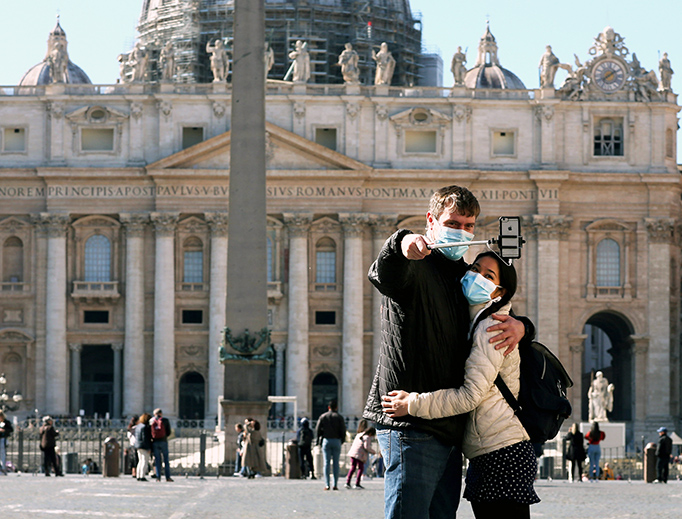 Vatican tourists wearing protective masks take a selfie Thursday in front of St. Peter's Basilica. Vatican tourists wearing protective masks take a selfie Thursday in front of St. Peter's Basilica.
