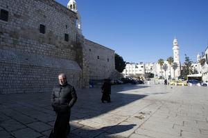 A priest walks in the Church of the Nativity compound in the occupied West Bank city of Bethlehem on March 8, after it came under lockdown two days ago as an emergency measure to limit the spread of the novel coronavirus. A priest walks in the Church of the Nativity compound in the occupied West Bank city of Bethlehem on March 8, after it came under lockdown two days ago as an emergency measure to limit the spread of the novel coronavirus.
