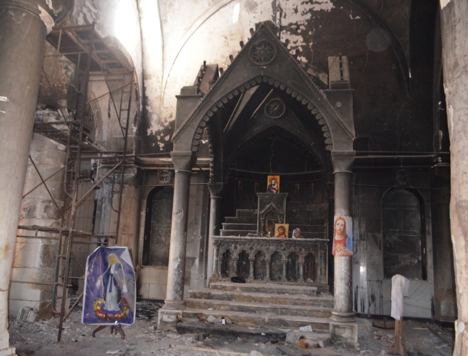 Above, Immaculate Conception Syriac Catholic Cathedral in Qaraquosh will hold Christmas celebrations, despite its damaged interior. Below, a view of ruined homes in Qaraqosh as Yohanna Towaya stands in front of his parents’ home. Above, Immaculate Conception Syriac Catholic Cathedral in Qaraquosh will hold Christmas celebrations, despite its damaged interior. Below, a view of ruined homes in Qaraqosh as Yohanna Towaya stands in front of his parents’ home.