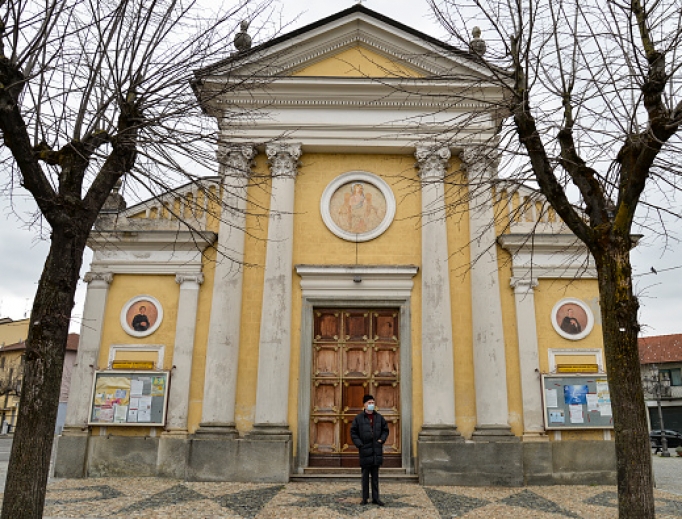 Don Carlo Chiomento, of the Church of St. John the Baptist in the Candiolo municipality of Turin, Italy, wears a mask as he stands outside his closed church. Don Carlo Chiomento, of the Church of St. John the Baptist in the Candiolo municipality of Turin, Italy, wears a mask as he stands outside his closed church.
