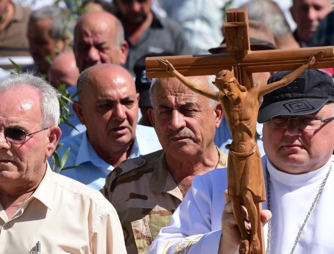 A religious procession takes place in Qaraqosh, Iraq. Father Andrzej Halemba, shown at front right holding the crucifix, is the Middle East head of Aid to the Church in Need; the aid organization says the situation is dire for Iraqi Christians. A religious procession takes place in Qaraqosh, Iraq. Father Andrzej Halemba, shown at front right holding the crucifix, is the Middle East head of Aid to the Church in Need; the aid organization says the situation is dire for Iraqi Christians.