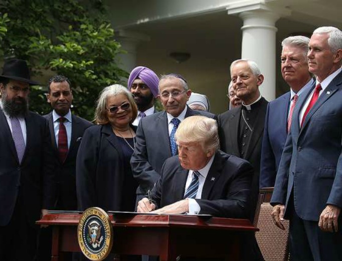 President Donald Trump is flanked by religious leaders as he signs an executive order on religious freedom May 4 at the White House. President Donald Trump is flanked by religious leaders as he signs an executive order on religious freedom May 4 at the White House.