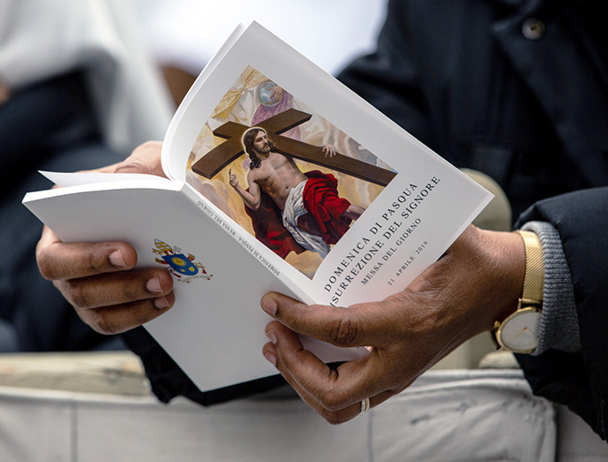 A pilgrim follows along with a booklet as Pope Francis celebrates Easter Mass and the Urbi et Orbi Blessing in St. Peter's Square, April 22, 2019. A pilgrim follows along with a booklet as Pope Francis celebrates Easter Mass and the Urbi et Orbi Blessing in St. Peter's Square, April 22, 2019.